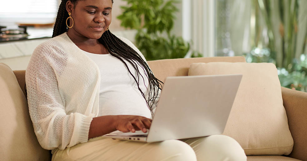 Pregnant student working on laptop