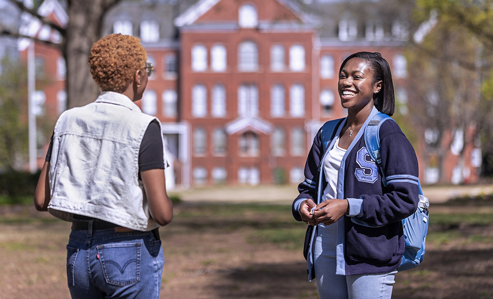 Two Students conversing on the campus yard