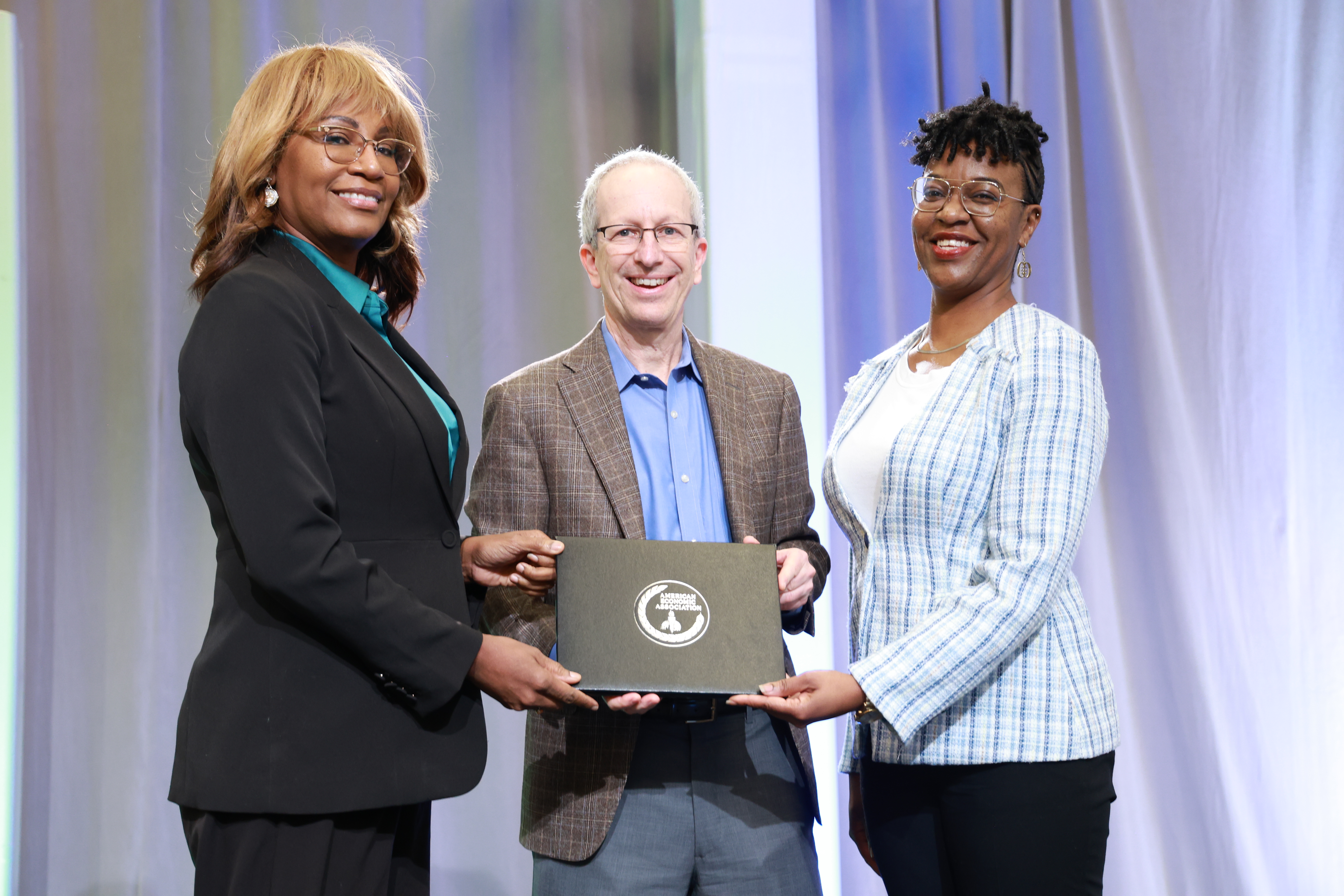 Dr. Holmes and Professor Suneye Holmes accept AEA award