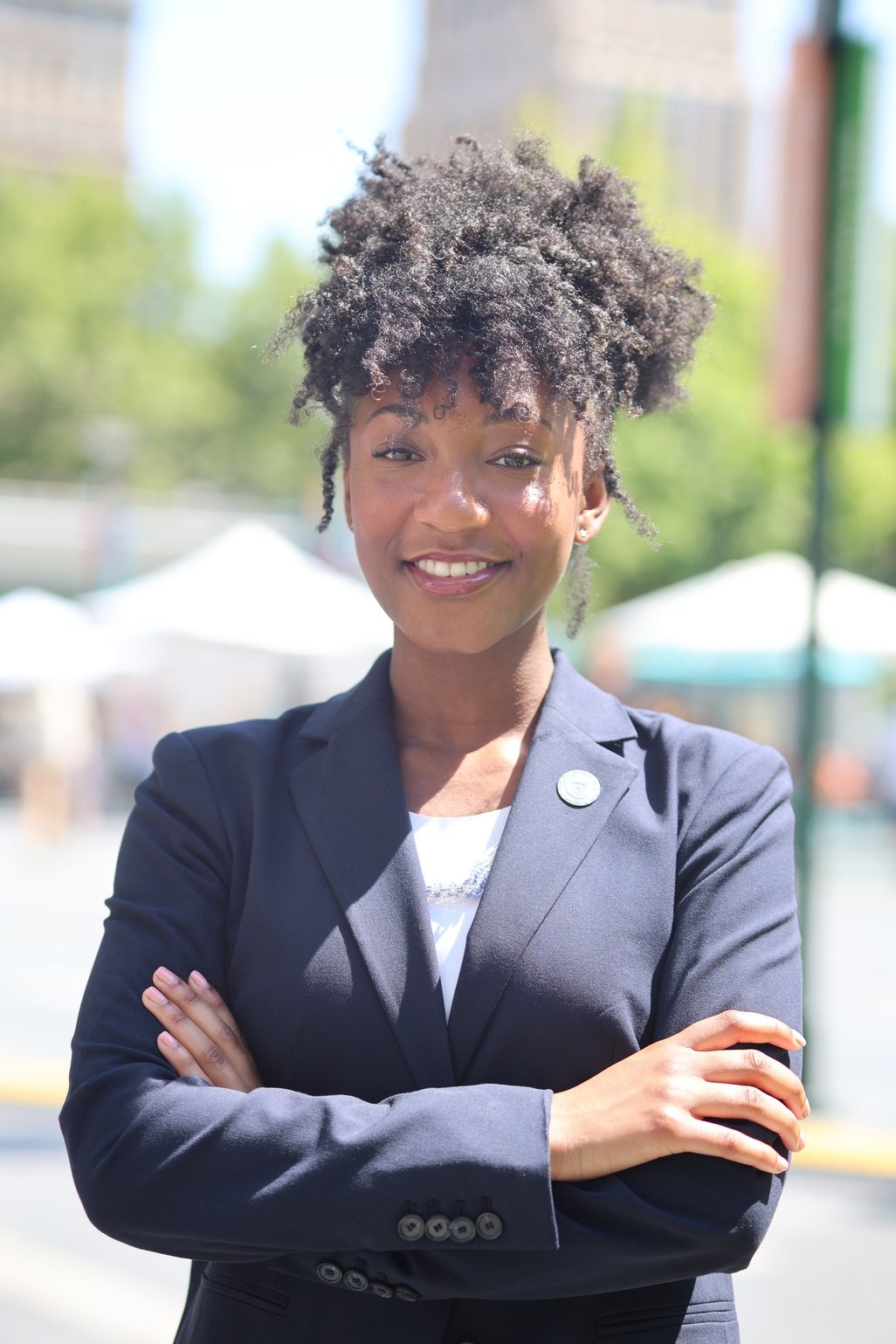 Laila Johnson smiling, with her arms crossed in front of her, in a powerful woman's pose.